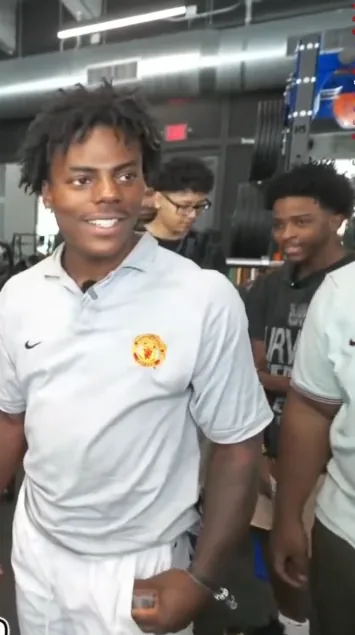 IShowSpeed in the foreground with Nitro Camden visible behind him inside a gym during a livestream.